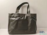 a brown leather tote bag sitting on top of a white table