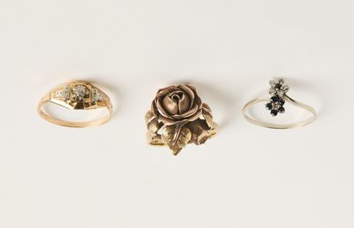 trois anneaux en or et une rose sur fond blanc