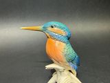 a figurine of a bird sitting on a branch