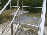 a set of metal steps leading up to the top of a hill