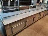 stainless steel counter top with glass shelves and drawers in a store