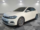 une Volkswagen Polo break blanche garée dans une pièce au sol à carreaux