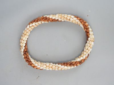a close up of a beaded bracelet on a white surface