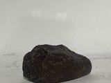 a rock that is sitting on the ground in the snow