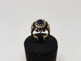 a close up of a gold ring with a sapphire and diamonds