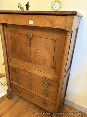 une commode en bois surmontée d'une horloge