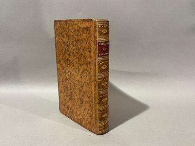 un vieux livre posé sur une table blanche à côté d'un mur blanc