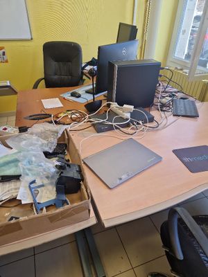 a desk with a laptop, monitor, and other electronics on it
