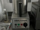 un mixeur argenté posé sur le plan de travail d'une cuisine
