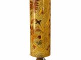 vase jaune et marron posé sur un socle en bois, sur fond blanc