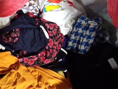 une pile de vêtements posée sur un lit