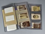 Plusieurs vieilles photos de voitures sont exposées dans un dossier posé sur une table