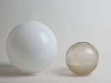 a glass ball and a glass vase sitting on a table