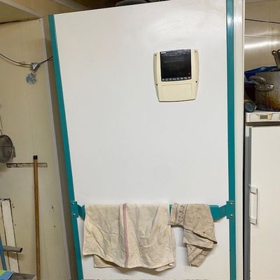 une photo d'un réfrigérateur dans une cuisine, avec une serviette accrochée à la porte