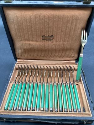 many forks and spoons in a case on the table