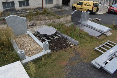 many tombstones that are sitting in the grass