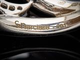 a pair of silver horseshoes sitting on top of a black surface