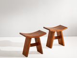 deux petits tabourets en bois posés sur une surface blanche