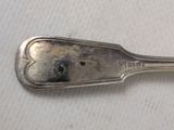 a silver spoon with a heart on it sitting on a table