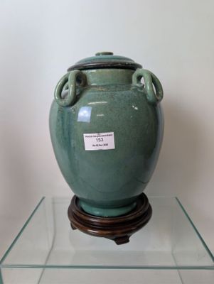 a green vase sitting on top of a glass table