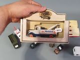 a hand holding a small toy truck with a box on it