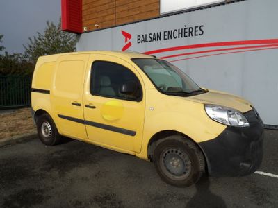 La petite camionnette jaune est garée devant un immeuble.
