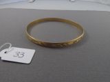 un bracelet en or avec une étiquette de prix posé sur un lit