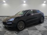 Une Porsche Cayenne noire est garée sur un sol à damier
