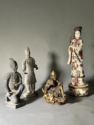 trois figurines représentant des hommes et des femmes asiatiques sont disposées sur une surface grise