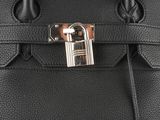 a close up of a black leather handbag with a lock