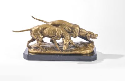 une statue en bronze représentant deux chiens, posée sur un socle en marbre