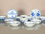 plusieurs assiettes et bols bleus et blancs posés sur une table en verre
