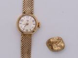 une image représentant une montre-bracelet en or et un pendentif en feuille d'or