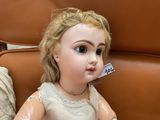 a doll that is sitting on a chair with a tag on it