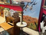 une lampe posée sur une table devant un tableau