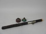 une pipe avec un manche en bois à côté d'une petite bouteille