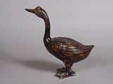 a small wooden duck that is sitting on a table