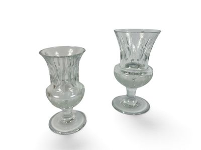 two glass vases sitting next to each other on a white surface