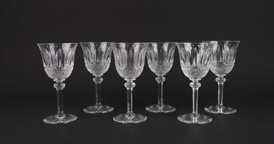 a set of six crystal wine glasses on a black background