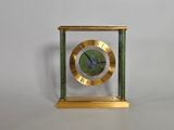 une image représentant une horloge aux couleurs or et vert, avec des chiffres romains sur le cadran