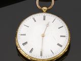 an antique gold pocket watch with roman numerals on the face