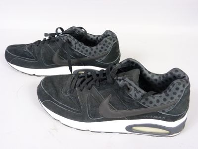 une paire de baskets noires ornées de pois sur fond blanc