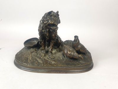statue en bronze représentant un chien et deux canards sur un rocher
