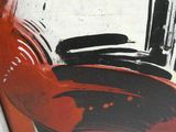 une photo d'un vase rouge recouvert de peinture noire et blanche