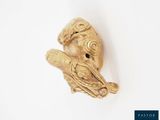 une sculpture en or représentant un oiseau perché sur une branche