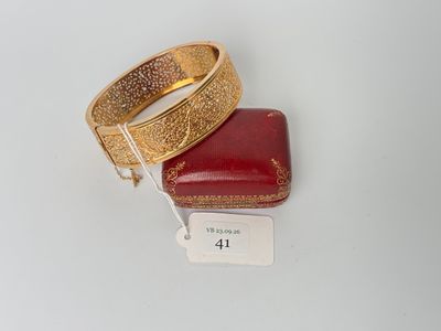 two gold bracelets on a red box with a price tag