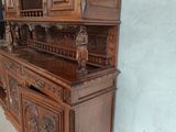 a wooden china cabinet with a carved design on it