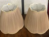 deux lampes posées sur une table en bois, avec un mur en arrière-plan