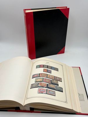 un livre ouvert posé sur une table blanche, à côté d'un livre rouge et noir