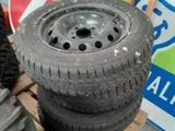 les pneus sont empilés sur une palette à côté d'une pile de panneaux